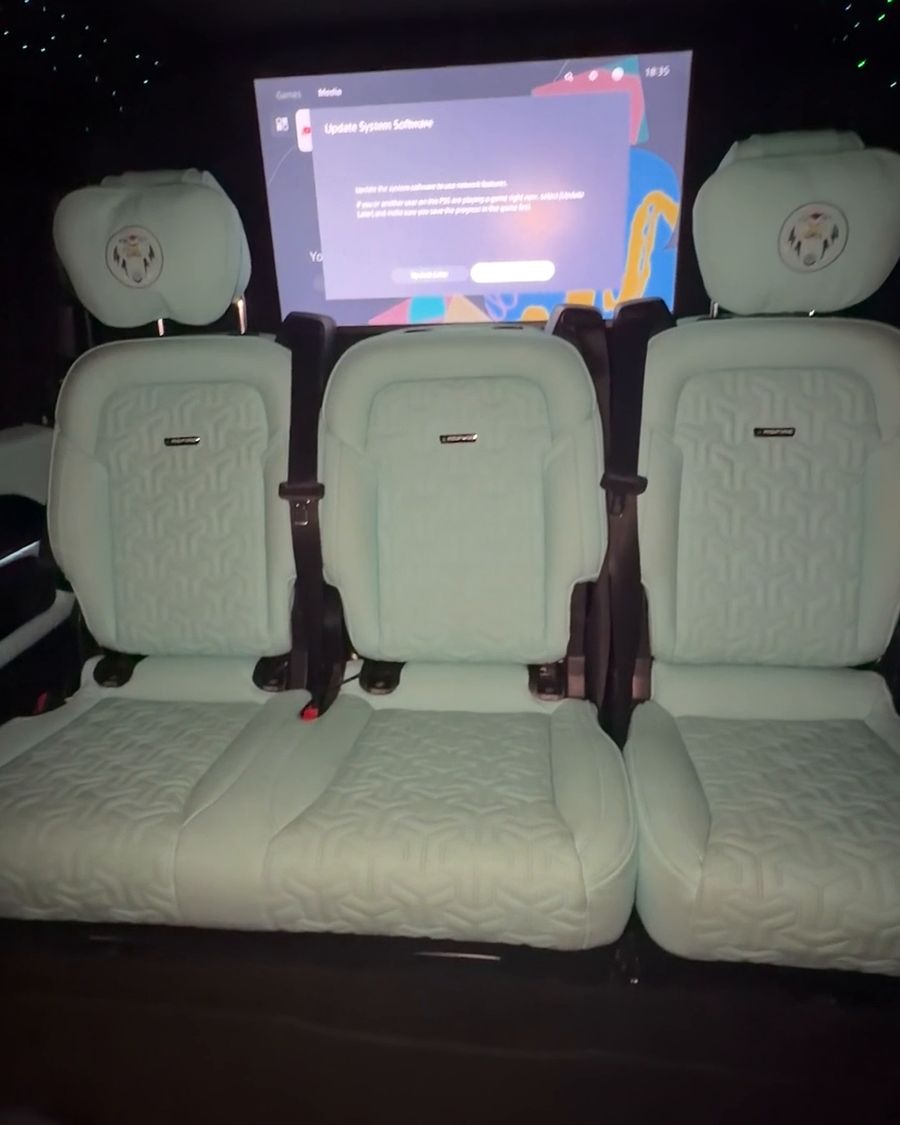 Large screen showing the PlayStation 5 menu behind the rear seats