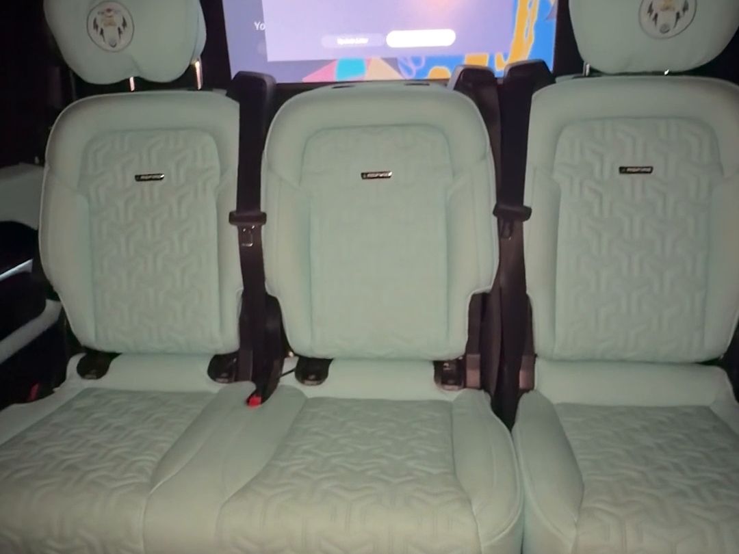 Large onboard screen showing the PlayStation 5 menu above the rear seats