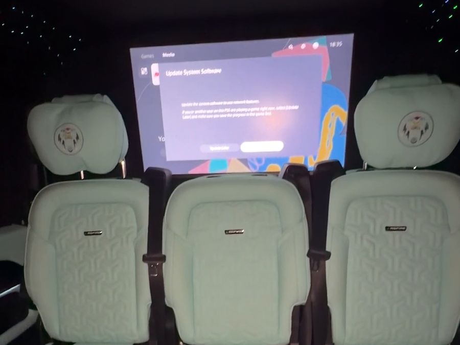 Three turquoise leather seats facing the large onboard screen
